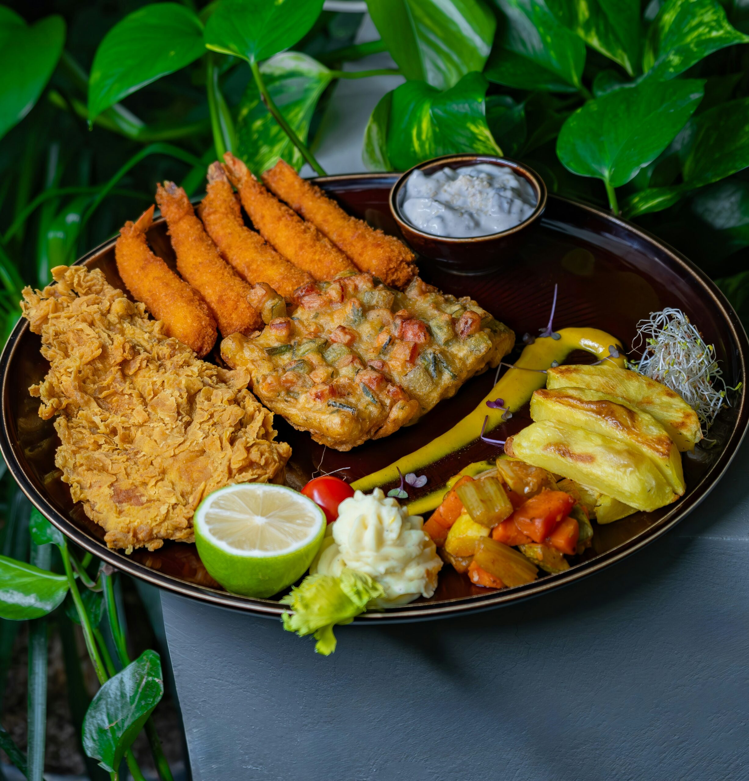 different kinds of fried food and fruits on a black plate